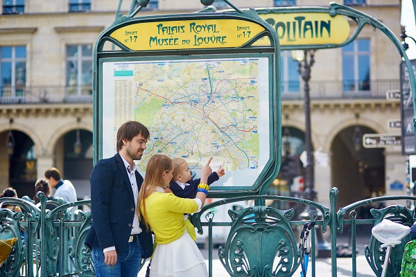 Family of three in Paris, looking at the Parisian subway map