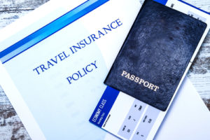 Travel insurance policy booklet with a boarding pass and a passport