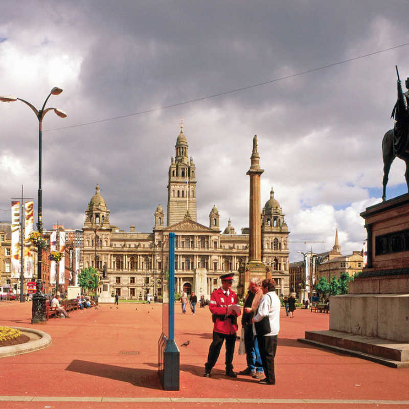 A CITY GUIDE CHATS TO TOURISTS IN GEORGE SQUARE, WITH A VIEW BEYOND TO THE CITY CHAMBERS, IN THE CITY CENTRE OF GLASGOW. PIC: VisitScotland/SCOTTISH VIEWPOINT Tel: +44 (0) 131 622 7174 Fax: +44 (0) 131 622 7175 E-Mail : info@scottishviewpoint.com This photograph can not be used without prior permission from Scottish Viewpoint.