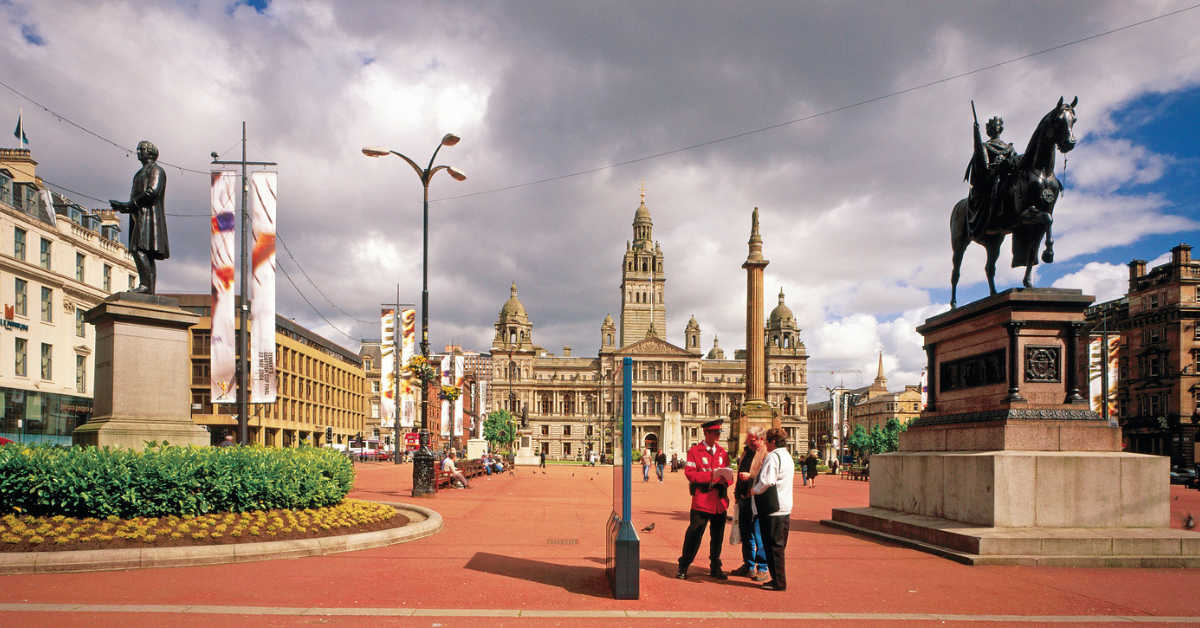 A CITY GUIDE CHATS TO TOURISTS IN GEORGE SQUARE, WITH A VIEW BEYOND TO THE CITY CHAMBERS, IN THE CITY CENTRE OF GLASGOW. PIC: VisitScotland/SCOTTISH VIEWPOINT Tel: +44 (0) 131 622 7174 Fax: +44 (0) 131 622 7175 E-Mail : info@scottishviewpoint.com This photograph can not be used without prior permission from Scottish Viewpoint.